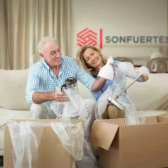 Pareja embalando ropa en cajas de mudanza 60x40x40 durante una mudanza
