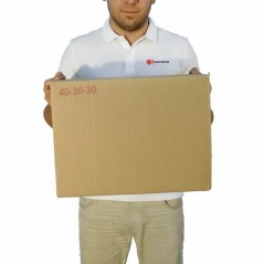 Caja de cartón 40x30x30 sostenida a mano en depósito mayorista, escala real — SonFuertes