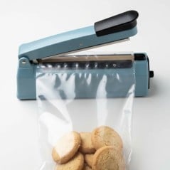 Bolsa de polipropileno 17x25 con galletitas colocada en una selladora eléctrica de bolsas para el cierre térmico