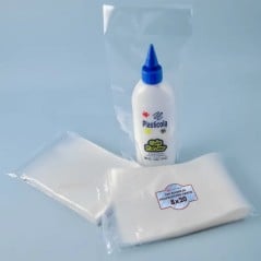Dos packs de 200 bolsas de polipropileno cristal 8x20 SonFuertes junto a un envase de adhesivo escolar embolsado