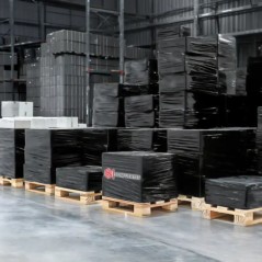 Pallets completos envueltos con film stretch negro en depósito logístico
