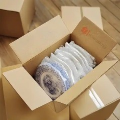 Platos de loza embalados uno por uno con plástico de burbujas SonFuertes® dentro de una caja de cartón