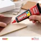 Manos aplicando Unipox Extra Fuerte 100 ml sobre madera balsa para pegar un retazo de cuero